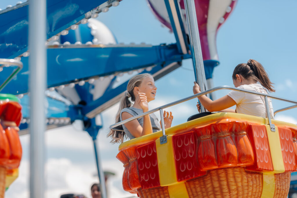 Two girls having fun on a hot air balloon ride at amusement park