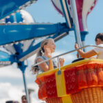 Two girls having fun on a hot air balloon ride at amusement park